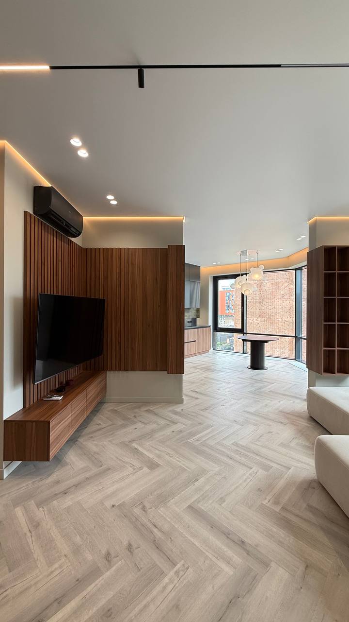 Белая встроенная прихожая с деревянной подсвеченной секцией