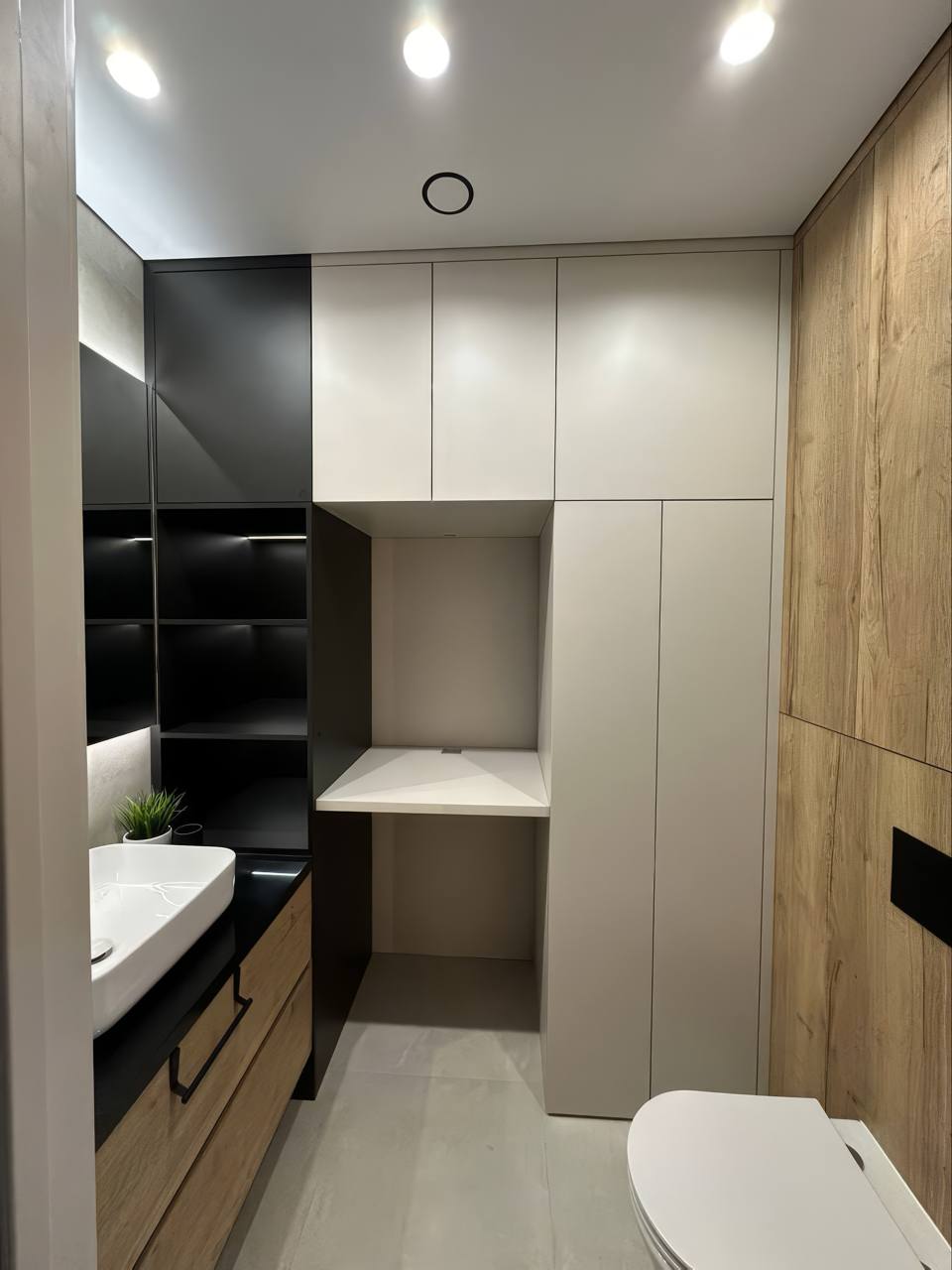 Компактный санузел со встроенной нишей, хранением и светлой мебелью
